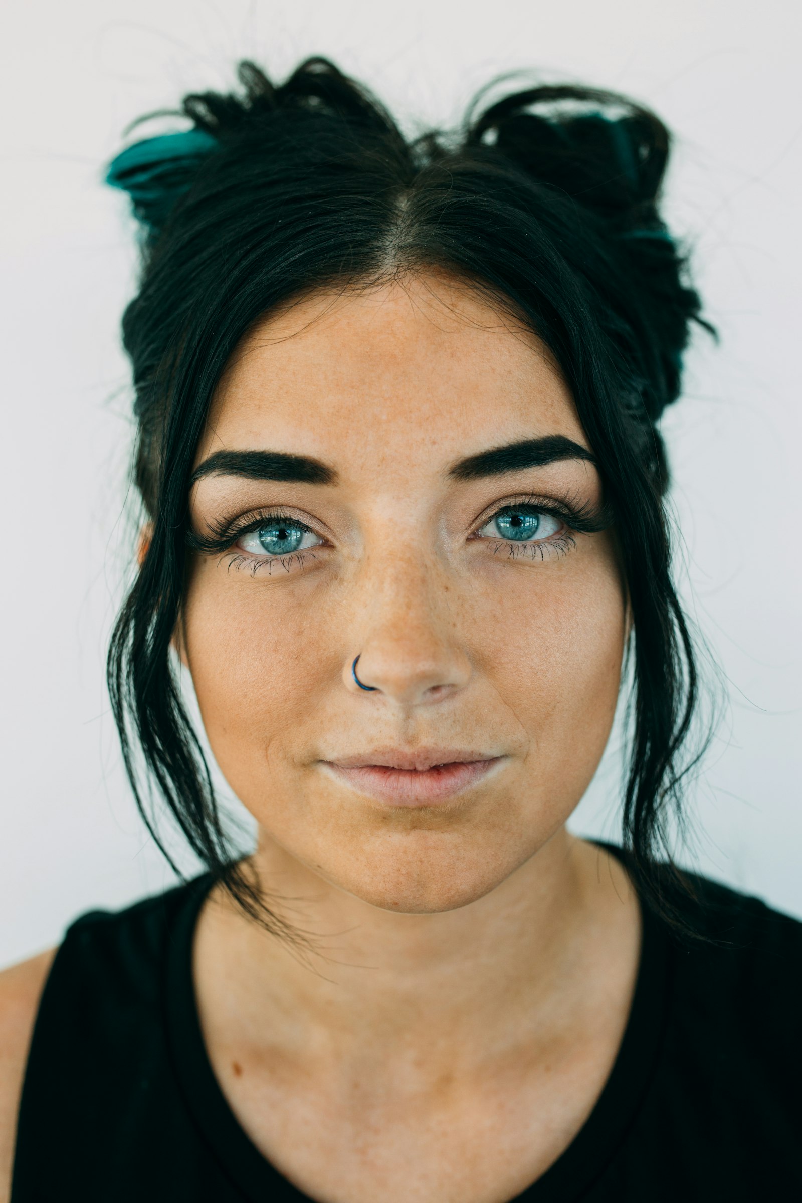 A close portrait of a woman with freckles and bright blue eyes
