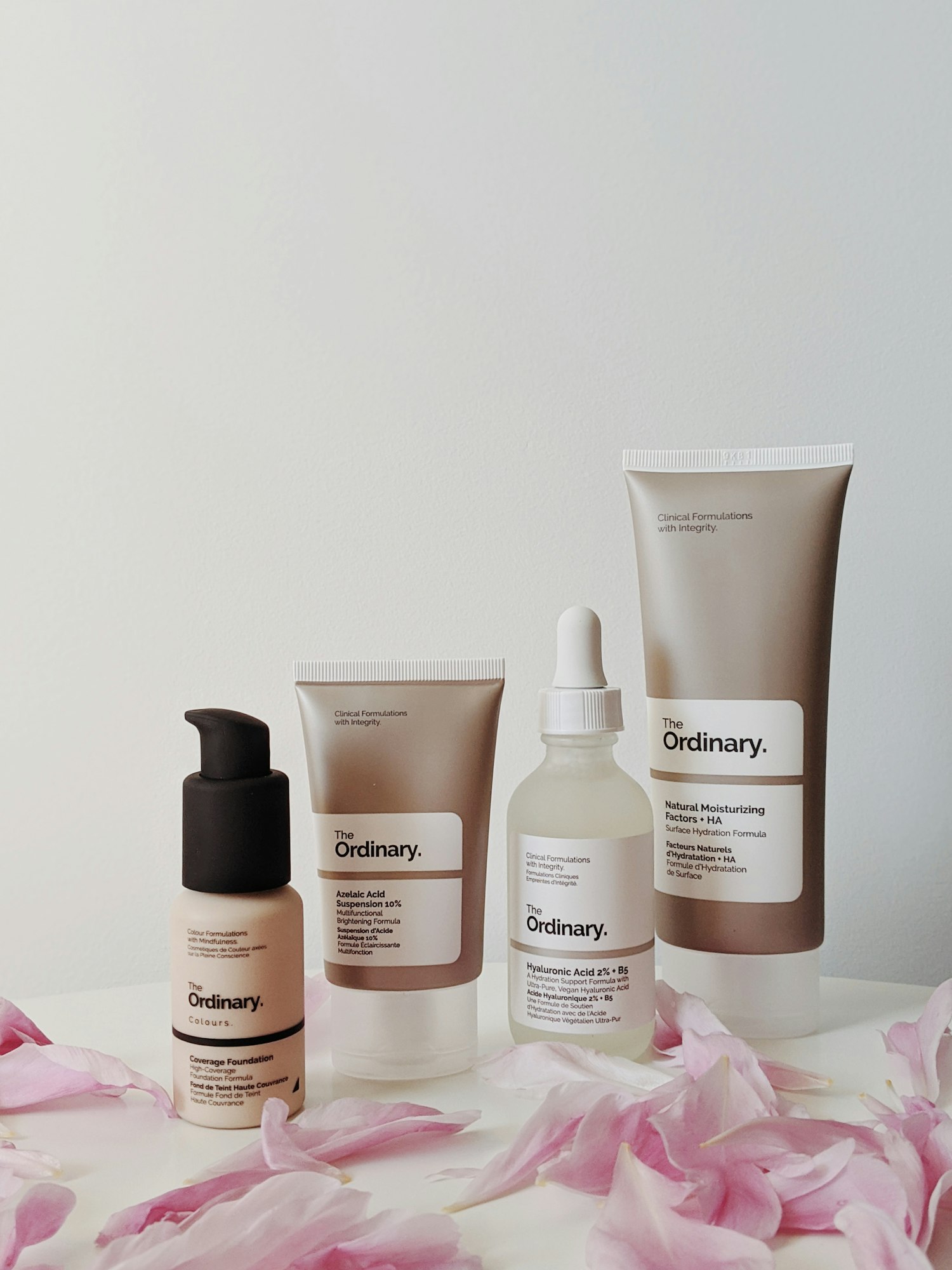 Amber glass dropper bottles and rose-toned skincare packaging arranged on a dark surface
